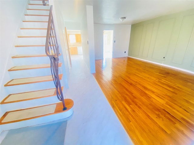 staircase with a decorative wall and wood finished floors