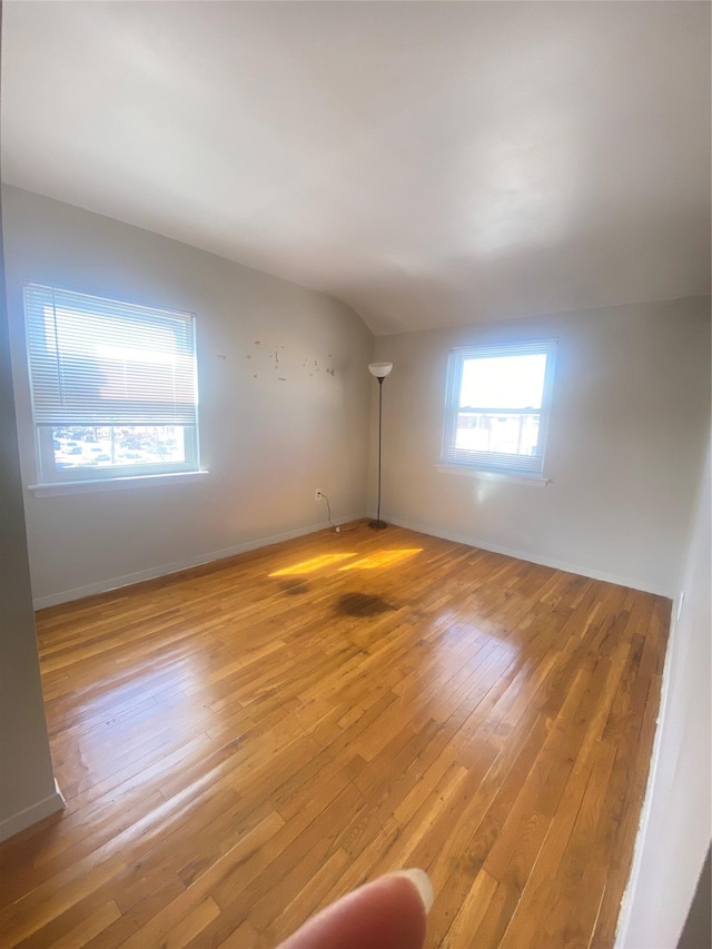 empty room featuring baseboards and hardwood / wood-style floors