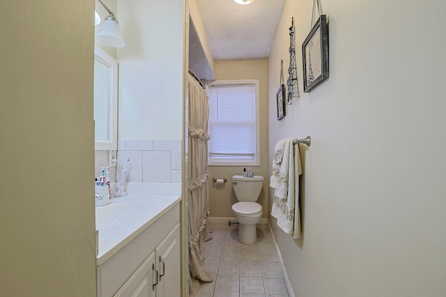 bathroom featuring baseboards, vanity, toilet, and tile patterned floors