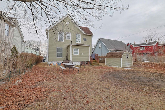 back of house with a storage unit and an outdoor structure