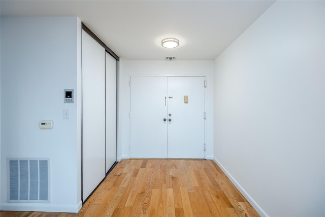 entryway featuring light wood finished floors, baseboards, and visible vents