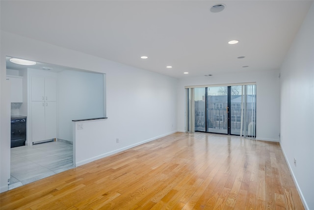 spare room with light wood-type flooring, baseboards, and recessed lighting