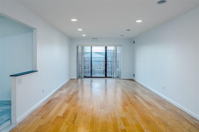 spare room with light wood finished floors, baseboards, and recessed lighting