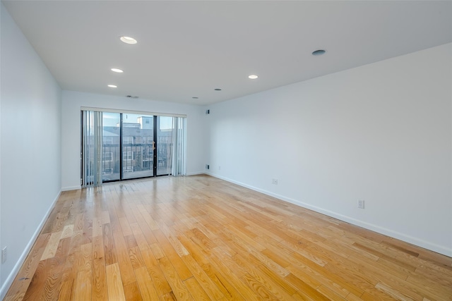 spare room with light wood-style floors, baseboards, and recessed lighting