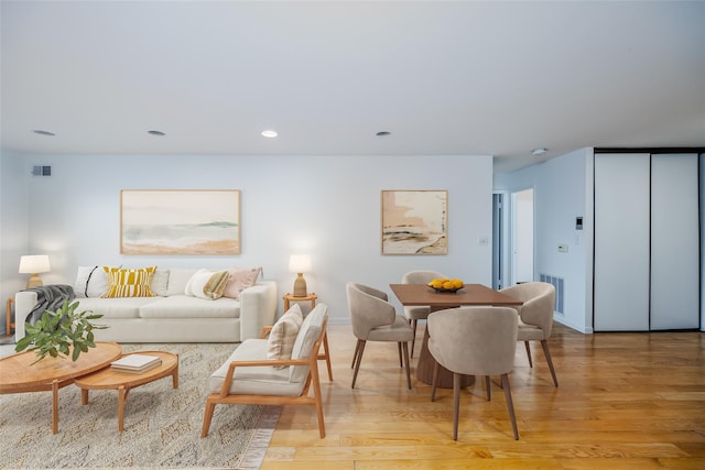 living area featuring light wood-style floors, recessed lighting, visible vents, and baseboards