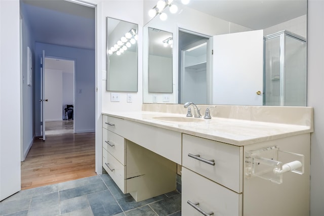 full bathroom with a shower with door and vanity