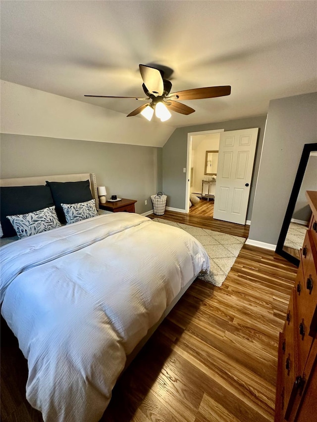 bedroom with vaulted ceiling, wood finished floors, a ceiling fan, and baseboards