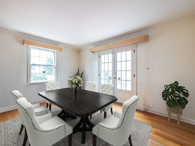 dining room featuring plenty of natural light, french doors, ornamental molding, and light wood-type flooring