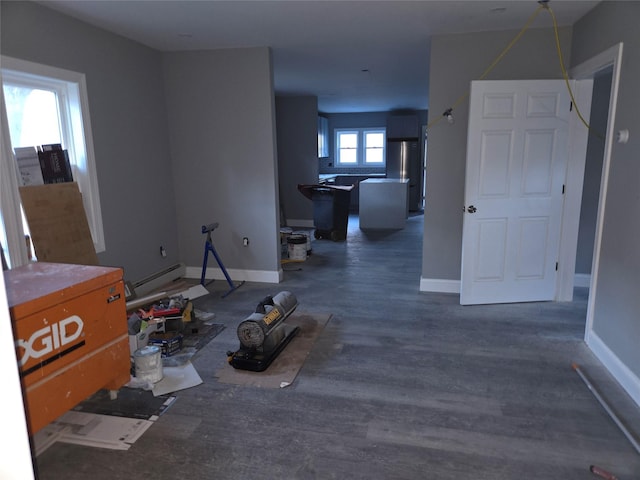 living area with dark wood-type flooring, baseboards, and baseboard heating