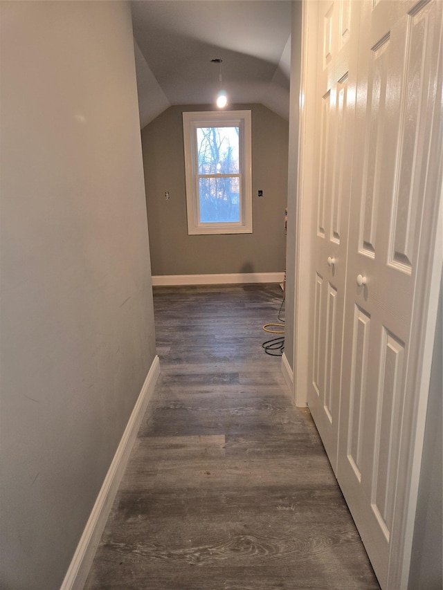 hall featuring dark wood finished floors, vaulted ceiling, and baseboards