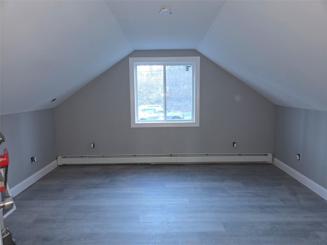 additional living space featuring baseboards, baseboard heating, and wood finished floors