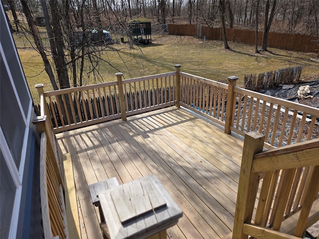 wooden terrace featuring a yard and fence