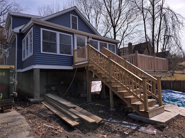 back of house with stairway, fence, a deck, and a sunroom