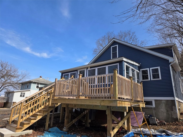 back of property with a deck and stairs