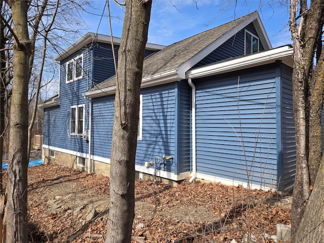 view of side of home featuring roof with shingles