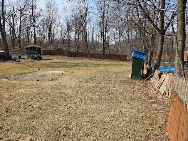 view of yard with an outdoor structure, fence, and a shed