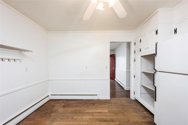 spare room featuring ornamental molding, baseboard heating, and wood-type flooring