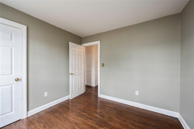 unfurnished bedroom with baseboards and dark wood finished floors