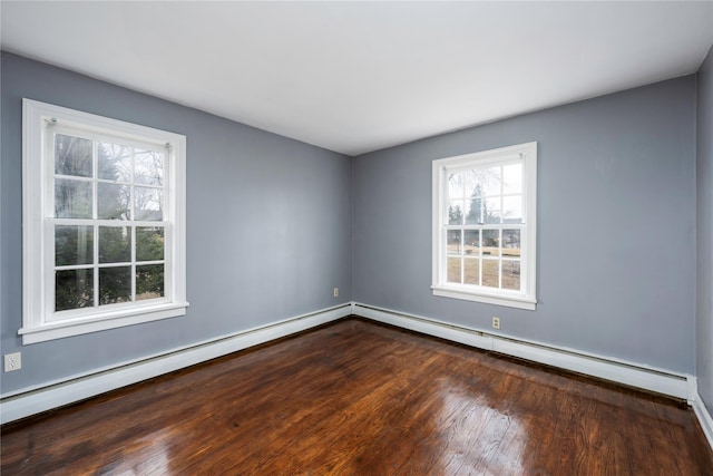 empty room featuring baseboard heating and wood finished floors