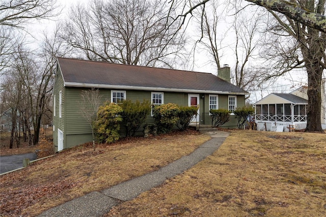 view of front of home featuring a sunroom and a chimney