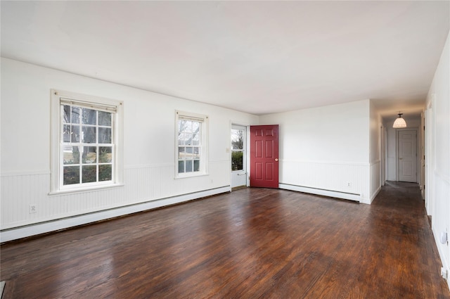 unfurnished living room featuring a baseboard heating unit, wood finished floors, and a wainscoted wall