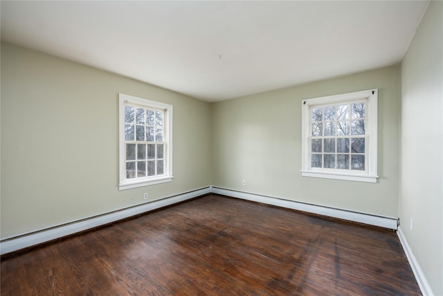 unfurnished room with baseboard heating, baseboards, and wood finished floors