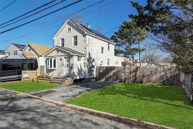 view of front of house featuring a chimney, fence, and a front yard