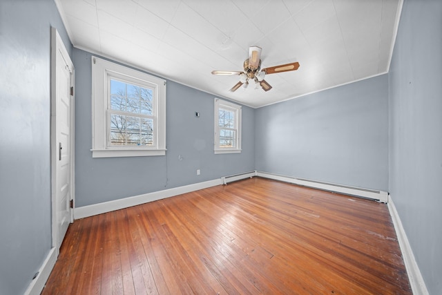 empty room with ceiling fan, wood-type flooring, baseboards, and baseboard heating