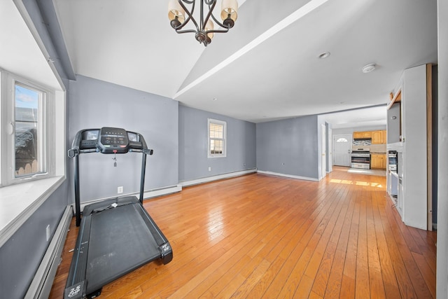 workout room featuring a baseboard radiator, light wood-style flooring, baseboards, and a chandelier