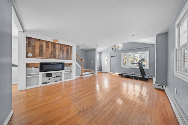 unfurnished living room featuring baseboards, a baseboard radiator, wood-type flooring, stairs, and a chandelier