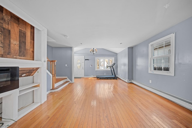 unfurnished living room with baseboards, a baseboard radiator, stairs, light wood-style floors, and a notable chandelier