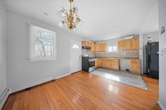 kitchen featuring stainless steel gas range oven, a baseboard radiator, light wood-style flooring, a sink, and freestanding refrigerator