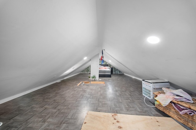 bonus room with lofted ceiling and baseboards