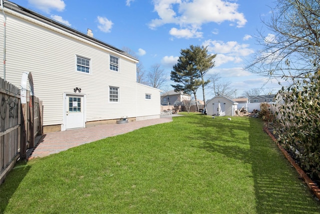 exterior space with an outbuilding, a fenced backyard, a patio, and a storage shed