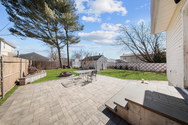 view of patio featuring a fire pit, a storage unit, an outdoor structure, and a fenced backyard