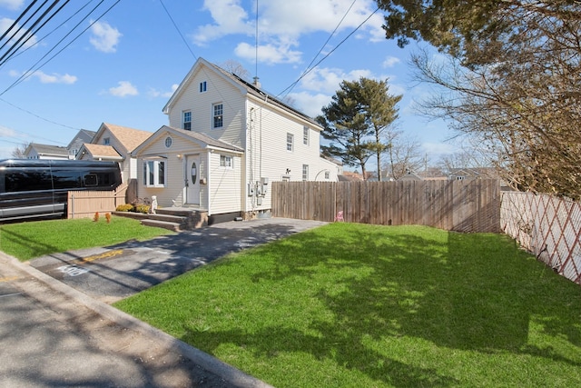 view of property exterior with a yard and fence