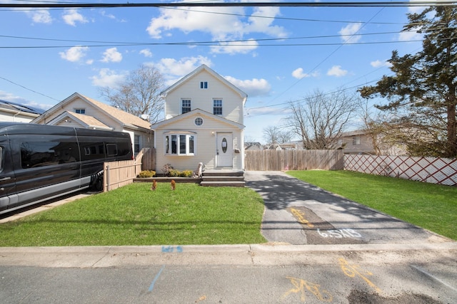 view of front facade featuring fence and a front lawn