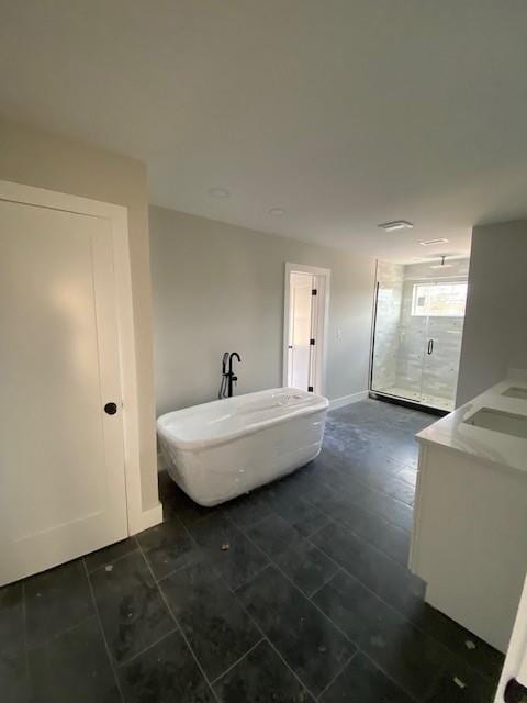 full bath with a soaking tub, baseboards, a shower stall, and vanity