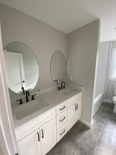 full bathroom with tile patterned floors, a sink, toilet, and double vanity