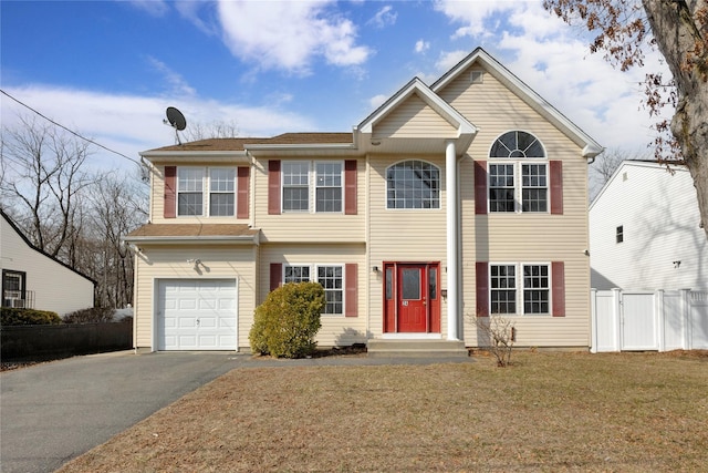 view of front of home with a garage, a front yard, driveway, and fence