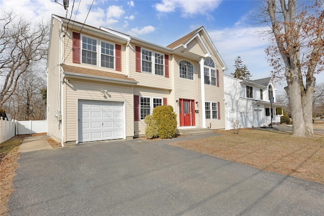 view of front of property featuring aphalt driveway, an attached garage, and fence