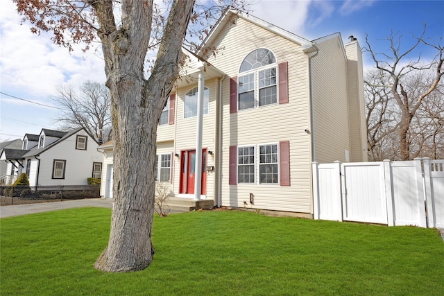 view of front of house featuring driveway, a front lawn, a chimney, and fence