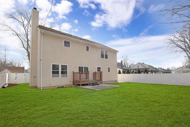 back of house with a deck, a lawn, a chimney, and a fenced backyard