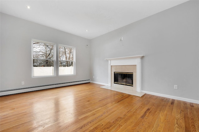 unfurnished living room with light wood finished floors, a baseboard radiator, a fireplace with flush hearth, and baseboards