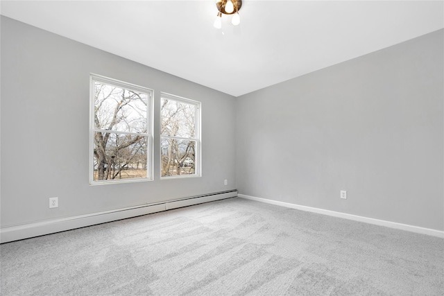 carpeted spare room with a baseboard heating unit and baseboards