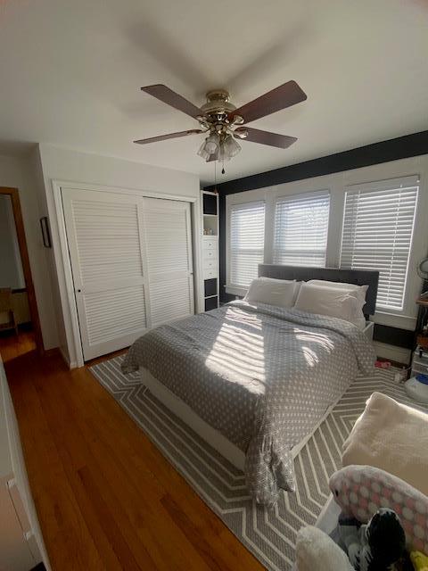 bedroom with ceiling fan, a closet, and wood finished floors