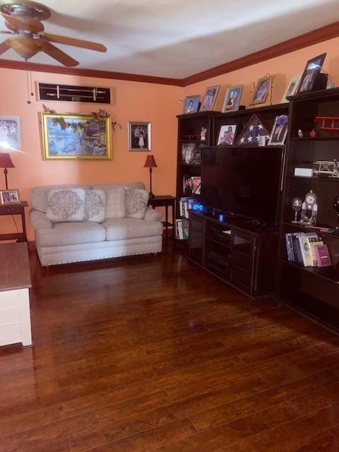 living area with a ceiling fan, wood finished floors, and crown molding