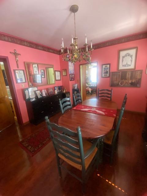 dining room with wood finished floors and a chandelier