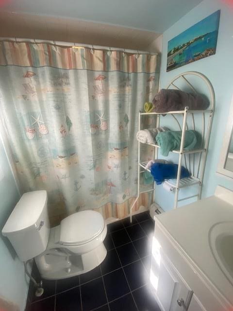 bathroom featuring tile patterned floors, toilet, vanity, and a shower with curtain