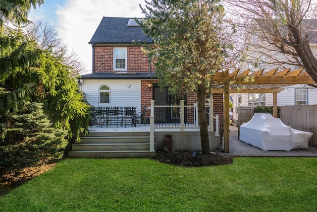 back of property with brick siding, fence, a wooden deck, a yard, and a pergola